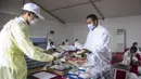 Jemaah mengambil makanan dalam kamp saat melaksanakan rangkaian ibadah haji di Kota Suci Makkah, Arab Saudi, Kamis (30/7/2020). Hanya sekitar seribu jemaah yang diizinkan untuk melakukan ibadah haji tahun ini karena pandemi COVID-19. (Saudi Ministry of Media via AP)