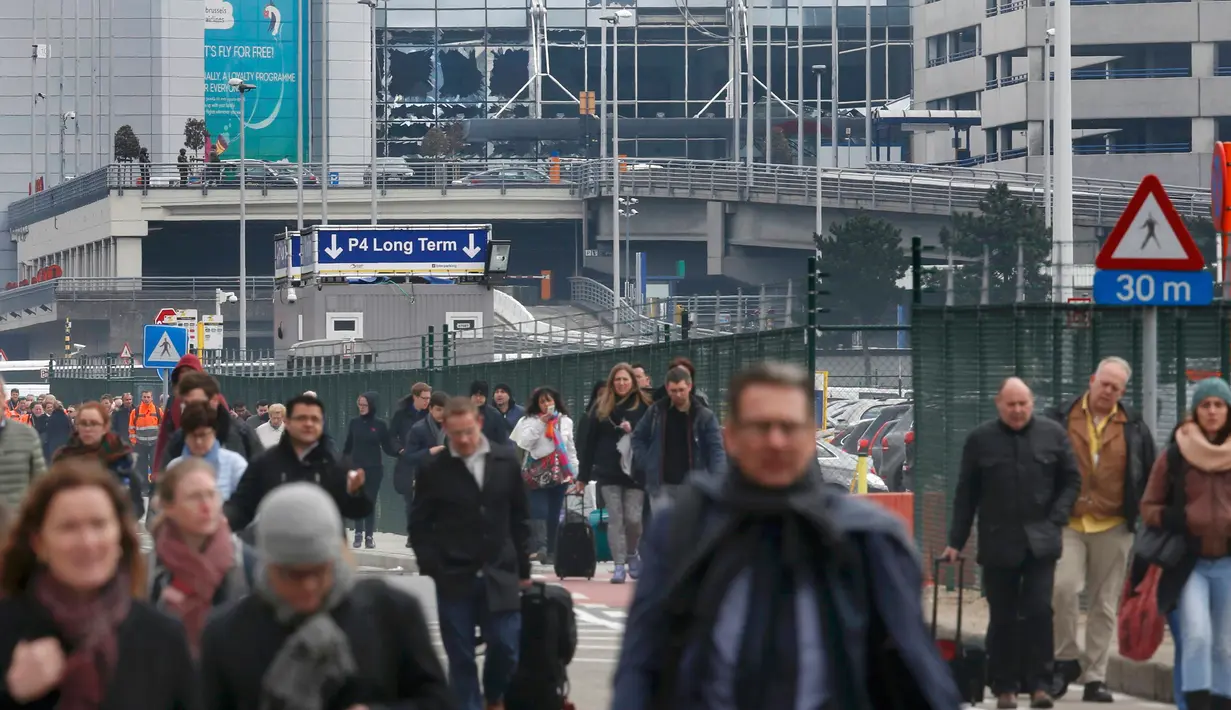 Sejumlah orang berjalan meninggalkan lokasi ledakan di bandara Zaventem dekat Brussels, Belgia, (22/3).Selain terjadi ledakan di Bandara, ledakan juga menghancurkan stasiun metro Maalbeek Brussels. (REUTERS / Francois Lenoir)