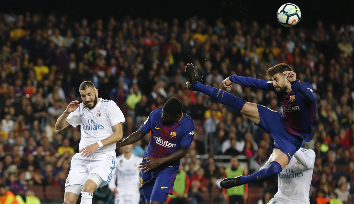Bek Barcelona, Gerard Pique, membuang bola dari jangkauan pemain Real Madrid pada laga La Liga Spanyol di Stadion Camp Nou, Barcelona, Minggu (6/5/2018). Kedua klub bermain imbang 2-2. (AFP/Pau Barrena)