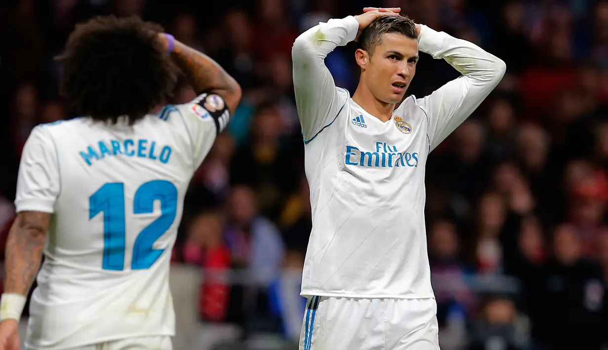 Reaksi pemain Real Madrid, Cristiano Ronaldo dan Marcelo selama pertandingan pekan ke-12 Divisi Primera La Liga Spanyol kontra Atletico Madrid di Stadion Wanda Metropolitano, Sabtu (18/11). Laga Derbi Madrid itu berakhir imbang tanpa gol. (AP/Paul White)