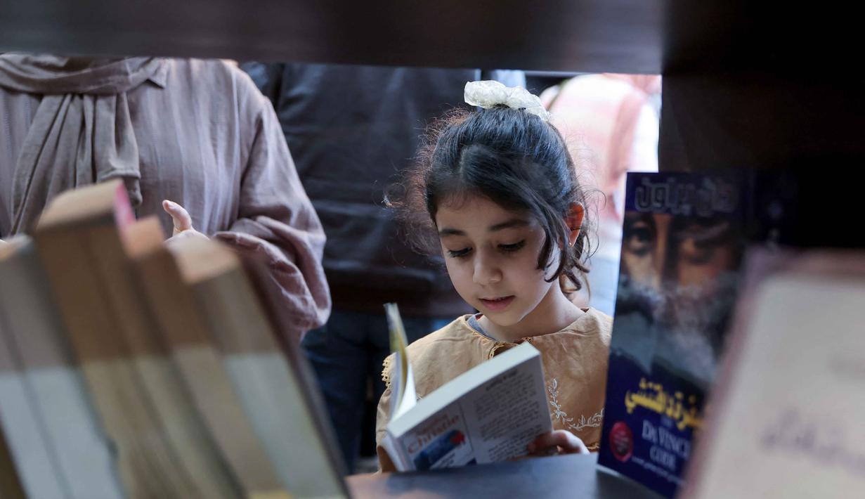 Perpustakaan yang terletak di lingkungan Rimal, Kota Gaza, menjadi ruang belajar alternatif, dan harapan di tengah kehancuran akibat serangan Israel sejak Oktober 2023. Tampak dalam foto, seorang gadis pengungsi Palestina membaca buku di perpustakaan Al-Ankaa (Phoenix), perpustakaan pertama yang dibuka sejak gencatan senjata di Jalur Gaza yang berisi buku-buku yang diselamatkan dari perpustakaan yang hancur selama perang Israel-Hamas, di lingkungan Rimal, Kota Gaza pada Selasa 21 April 2026. (Omar AL-QATTAA/AFP)