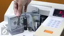 Petugas menghitung Dolar AS menggunakan mesin, Jakarta, Selasa (7/6). Mata uang dollar AS terus melemah terhadap rupiah sejak dibuka tadi pagi. (Liputan6.com/Angga Yuniar)