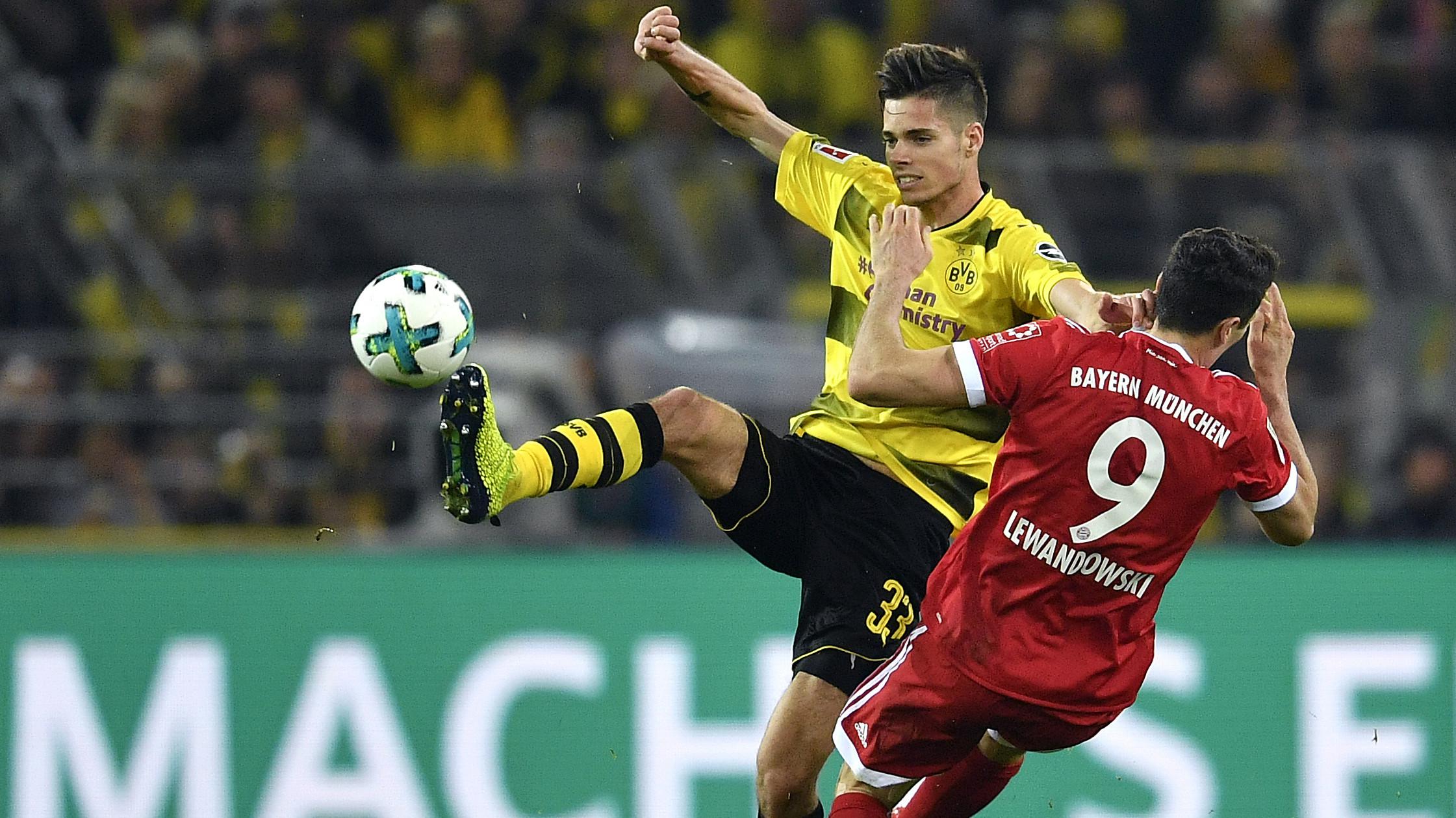 Pemain Dortmund, Julian Weigl (kiri) menghalau bola dari kejaran pemain Bayern, Robert Lewandowski pada lanjutan Bundesliga di Signal Iduna Park, Dortmund, (4/11/2017). Bayern menang 3-1. (AP/Martin Meissner)