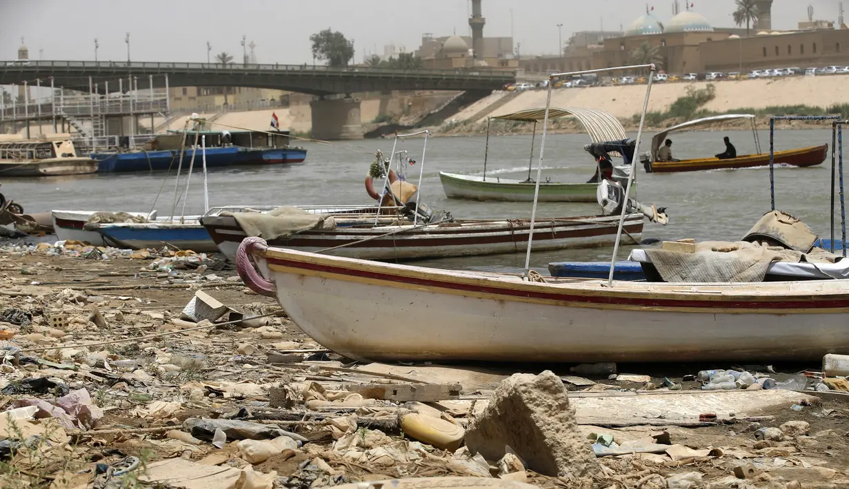 Kapal feri kayu ditambatkan di sepanjang tepi kanan sungai Tigris dekat jembatan al-Ahrar (Latar Belakang) saat permukaan air sungai semakin dangkal, di pusat ibu kota Irak, Baghdad, pada 26 Mei 2022. Ketinggian air di dua sungai utama Irak telah menurun secara signifikan dalam beberapa tahun terakhir, menjadi tantangan besar yang dihadapi negara semi-gurun berpenduduk 41 juta jiwa itu. (AHMAD AL-RUBAYE/AFP)