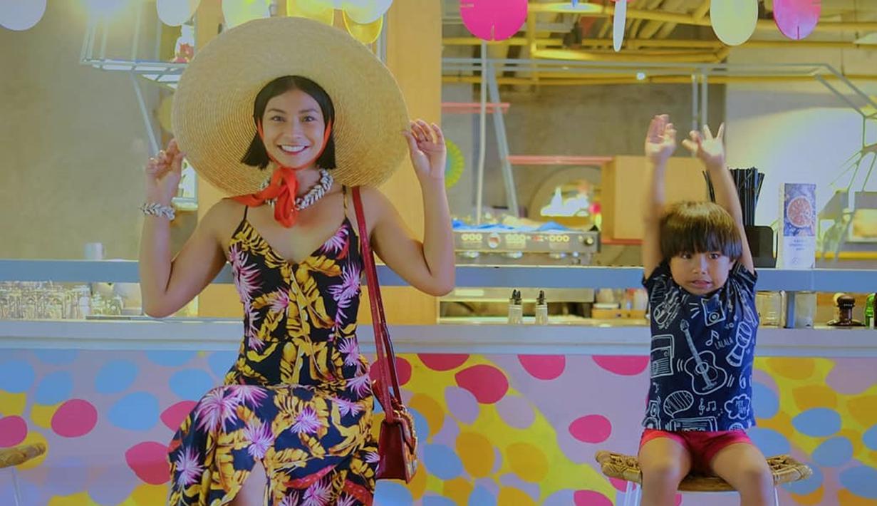 Wanita 37 tahun ini tampil kompak bergaya ala musim panas di cafe kekinian bersama putra semata wayangnya. Punya potongan rambut yang sama, ibu dan anak ini terlihat mirip ya! (Liputan6.com/IG/@shareefadaanish)