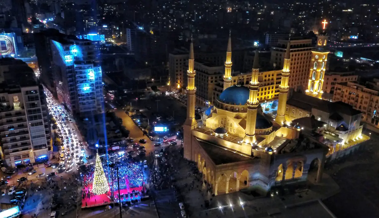 Pemandangan dimana saat pohon natal dipajang bersebelahan dengan Masjid Mohammad al-Amin di Beirut, Lebanon (10/12). Menyambut datangnya natal, warga Beirut merayakan peresmian pohon natal tersebut. (AFP Photo/Stringer)