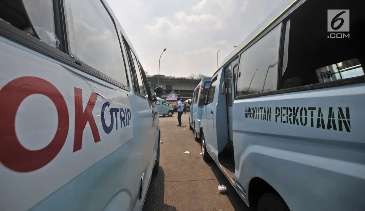 Angkot terparkir bersebelahan dengan mobil OK Otrip saat mangkal di Terminal Kampung Melayu, Jakarta, Selasa (10/7). Pemprov DKI menargetkan seluruh operator angkot bergabung dengan program OK Otrip pada akhir Juli 2018. (Merdeka.com/Iqbal Nugroho)