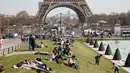Sejumlah pengunjung sedang menikmati musim semi yang hangat dan cerah di Trocadero square di dekat menara Eiffel, Paris, Kamis (9/4/2015). (REUTERS/Charles Platiau)