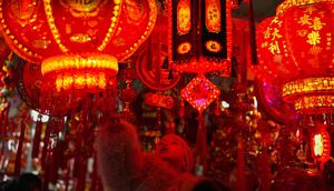 Beragam dekorasi khas perayaan Tahun Baru Imlek mulai ramai diperdagangkan. Tampak dalam foto, seorang balita yang digendong melihat dekorasi kemakmuran di sebuah stan untuk menyambut Tahun Baru Imlek, di sebuah Bazaar, Beijing, China, Minggu 1 Februari 2026. (AP Photo/Andy Wong)