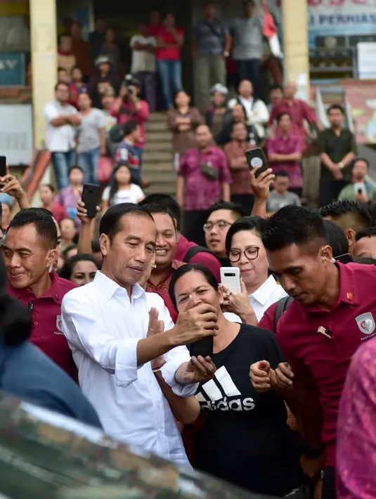 Presiden Joko Widodo berswafoto dengan warga saat meninjau rencana revitalisasi Pasar Sukawati di Gianyar, Bali, Jumat (14/6/2019). Jokowi yang ditemani Ibu Negara Iriana mengawali kunjungan kerja ke Bali dengan meninjau Pasar Sukawati. (Liputan6.com/Pool/Biro Pers Setpres)