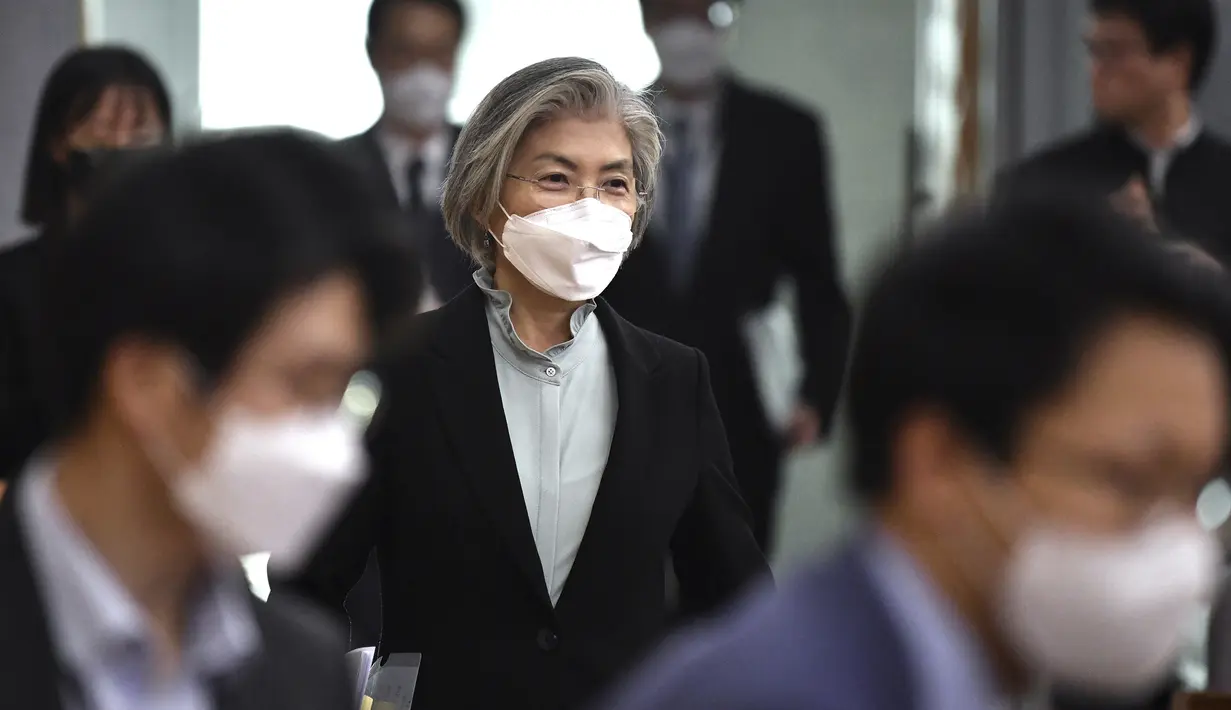 Menteri Luar Negeri Korea Selatan Kang Kyung-wha (tengah) mengenakan masker tiba untuk menghadiri konferensi untuk diplomat asing tentang situasi wabah virus corona di Korea, di kementerian luar negeri di Seoul, Jumat (6/3/2020). (Jung Yeon-je/Pool Photo via AP)