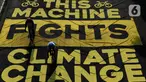 Pesepeda melintas di atas banner yang dibentangkan aktivis Greenpeace dan Bike2Work di Jalan Jenderal Sudirman, Jakarta, Minggu (5/6/2022). Aksi untuk mengkampanyekan penggunaan sepeda sebagai kendaraan ramah lingkungan dan solusi pembangunan Jakarta Kota Ramah Pesepeda. (Liputan6.com/Helmi Fithriansyah)