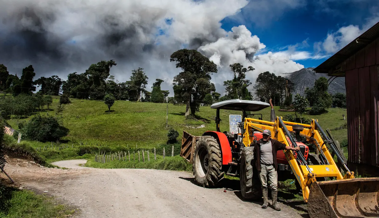 Warga berada di dekat gunung Turrialba, Cartago, 35 km dari San Jose, Kosta Rika (6/1). Akibatnya bencana ini sejumlah jadwal penerbangan dibatalkan dan penduduk yang tinggal di lereng diungsikan akibat material abu vulkanik. (AFP Photo/Ezequiel Becerra)