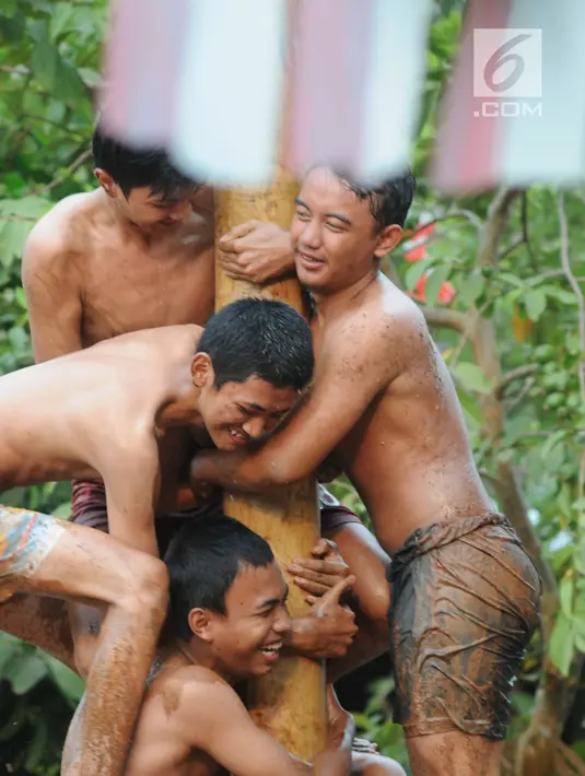 Para peserta berupaya mangambil hadiah, pada lomba panjat pinang di Perumahan Griya Pamulang 2, Tangerang Selatan, Jumat (17/8). Lomba yang diselengarakan oleh Bina Remaja ini dalam rangka memeriahkan HUT Ke-73 RI. (Merdeka.com/Dwi narwoko)