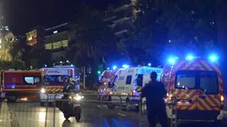 Petugas kepolisian dan kendaraan medis dikerahkan ke lokasi serangan teror truk di Nice, Prancis, Kamis (14/7). Setidaknya 60 orang tewas saat sebuah truk menabrak kerumunan ramai yang merayakan libur nasional Bastille Day. (REUTERS/ Jean-Pierre Amet)