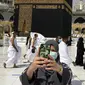 Umat muslim memakai masker untuk membantu menghentikan penyebaran virus corona COVID-19 saat berswafoto di Masjidil Haram, Makkah, Arab Saudi, Minggu (30/5/2021). (AP Photo/Amr Nabil)