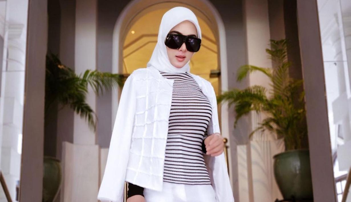 Tampil dalam hijab berwarna putih sesuai dengan busana yang digunakan, penampilan Syahrini satu ini terlihat memesona. Dirinya pun tak menggunakan aksesoris berlebih dan hanya mempercantik penampilan menggunakan kacamata hitam. (Liputan6.com/IG/@princessyahrini)