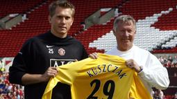 Kiper baru Manchester United, Tomasz Kuszczak (kiri) bersama pelatih Alex Fergison saat diperkenalkan pada sesi latihan terbuka di Old Trafford Stadium, Manchester (11/8/2006). Tomasz Kuszczak yang total membela Manchester United selama hampir 6 musim mulai 2006/2007 hingga tengah musim 2011/2012, didatangkan Setan Merah dari West Bromwich Albion yang harus terdegradasi pada akhir musim 2005/2006. Berstatus pinjaman selama semusim, MU mengeluarkan mahar sebesar 8,5 juta euro untuk sang kiper yang total tampil 61 laga dengan torehan 27 kali clean sheet. (AFP/Andrew Yates)