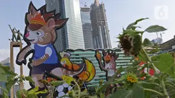 Maskot dan slogan Pekan Olahraga Nasional (PON) XX Papua terpasang di Bundaran Hotel Indonesia, Jakarta, Jumat (16/07/2021). Pemasangan maskot PON XX Papua itu bentuk promosi kegiatan pekan olahraga yang diselenggarakan tiap empat tahun sekali. (Liputan6.com/Herman Zakharia)