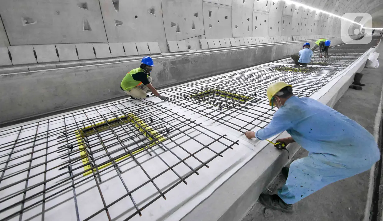 Pekerja menyelesaikan pengerjaan proyek Tunnel 1 Halim Kereta Cepat Jakarta-Bandung di Jalan Tol Jakarta-Cikampek KM 5+500, Jakarta, Kamis (27/1/2022). Tunnel 1memiliki panjang 1.885 meter dan dibangun dengan metode Tunnel Boring Machine (TBM). 
(Liputan6.com/Herman Zakharia)