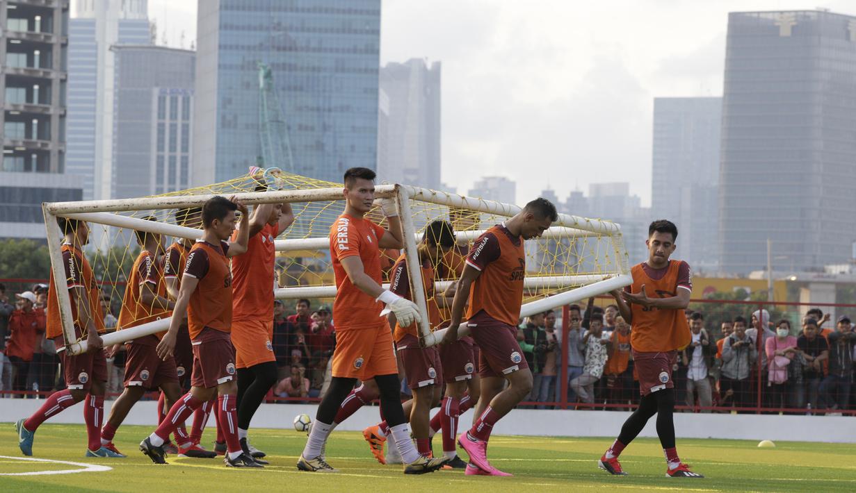 Pemain Persija Jakarta, menggotong gawang saat latihan di Lapangan Aldiron, Jakarta, Senin (7/1). Sebanyak 29 pemain sudah bergabung dalam latihan perdana tersebut. (Bola.com/M Iqbal Ichsan)