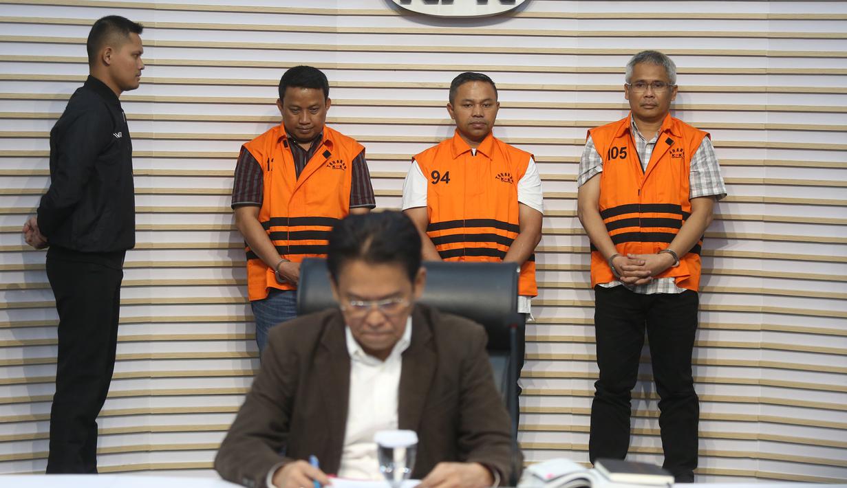 Gubernur Riau Abdul Wahid (kedua kanan belakang) menggunakan rompi tahanan saat dihadirkan pada rilis penetapan sekaligus penahanan usai menjalani pemeriksaan di Gedung Merah Putih Komisi Pemberantasan Korupsi (KPK), Jakarta, Rabu (5/11/2025). Selain Abdul Wahid, KPK juga menahan dua tersangka lainnya, yaitu Kepala Dinas PUPR-PKPP Muhammad Arief Setiawan dan Sekretaris Dinas PUPR-PKPP Ferry Yunanda. (merdeka.com/Arie Basuki)