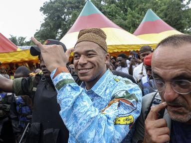 Pemain Paris Saint-Germain dan kapten Timnas Prancis, Kylian Mbappe (tengah) mengenakan pakaian tradisional saat mengunjungi desa ayahnya, Wilfrid Mbappe, di Djebale, Kamerun pada 8 Juli 2023. (AFP/Daniel Beloumou Olomo)