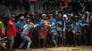 Orang-orang mengendalikan banteng di garis start selama kompetisi balap banteng Karapan Sapi di Bangkalan, pulau Madura, Jawa Timur, Minggu (16/10/2022). Lomba karapan sapi yang memperebutkan Piala Presiden itu diikuti 24 pasang sapi dari sejumlah daerah di Madura. (Juni Kriswanto/AFP)