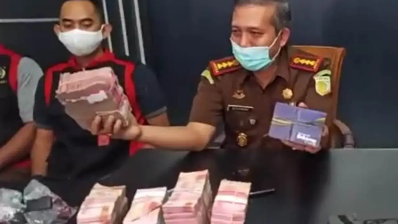 Kajari Purwokerto, Sunarwan, (kiri) menunjukkan barang bukti uang tunai Rp 470 juta yang disita dari rumah seorang saksi kasus dugaan korupsi dana JPS Kemenaker. (Foto: Liputan6.com/Kejari Purwokerto)