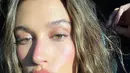 Hailey Bieber melakukan selfie, memamerkan kulit sehatnya dengan makeup minimum. Di sini, Hailey tampil dengan makeup minimum bernuansa merah muda yang cantik ketika terkena sinar matahari langsung. Foto: Vogue.