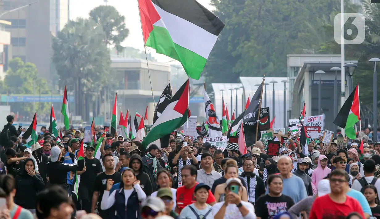 Sejumlah peserta aksi mengikuti aksi gerakan Global March to Gaza menuju kawasan Bundaran Hotel Indonesia, jalan MH Thamrin, Jakarta, Minggu (15/6/2025). (Liputan6.com/Herman Zakharia)
