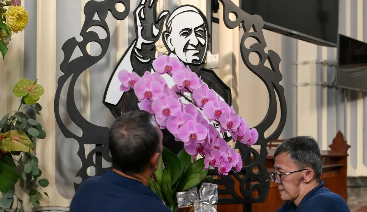 Potret Paus Fransiskus terlihat saat para pengurus gereja melakukan persiapan di Katedral Jakarta di Jakarta pada 21 April 2025, menyusul meninggalnya Paus Fransiskus di Vatikan. (BAY ISMOYO/AFP)