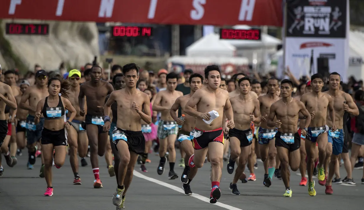 Peserta berlari dengan bertelanjang dada saat berpartisipasi pada The "Underpants Run" di Manila, Filipina, 8 April 2018. Kegiatan berkonsep fun run dengan pakaian dalam ini dimulai ketika matahari terbit. (NOEL CELIS / AFP)