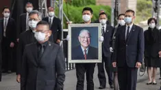James Zhao, cucu menantu mantan Presiden Taiwan Lee Teng-hui membawa potret Lee saat prosesi pemakaman di Pemakaman Militer Wuzhi Mountain di New Taipei City, Rabu (7/10/2020). Lee, yang dianggap sebagai "bapak demokrasi Taiwan", meninggal Juli lalu di usia 97 tahun. (Military News Agency via AP)