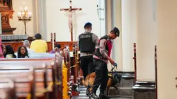 Sebagai informasi, Gereja Katedral Jakarta akan menggelar Misa malam Natal pada Rabu (24/12/2025) pukul 17.00 WIB dan 20.00 WIB. Sementara Misa Hari Raya Natal terbagi ke dalam tiga sesi pada Kamis 25 Desember 2025 mendatang. Tampak dalam foto, personel dari unit K9 kepolisian Indonesia menggeledah deretan kursi di dalam gereja selama operasi pengamanan menjelang perayaan Natal di Katedral Bunda Maria Diangkat ke Surga atau Gereja Katedral Jakarta, Selasa 23 Desember 2025. (AP Photo/Tatan Syuflana)