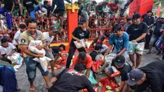 Orang-orang berebut untuk mendapatkan bahan makanan yang dibagikan kepada masyarakat umum selama Festival Hantu Lapar di Kuil Gie Yong Bio, Lasem, Jawa Tengah, pada 10 September 2025. (Foto: AFP)