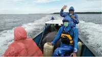 Tim Deru mengenakan jas hujan akibat cuaca yang tidak menentu saat melakukan perjalanan dengan perahu menuju Asmat. (IST/Dok Tim Deru UGM/Solopos.com)