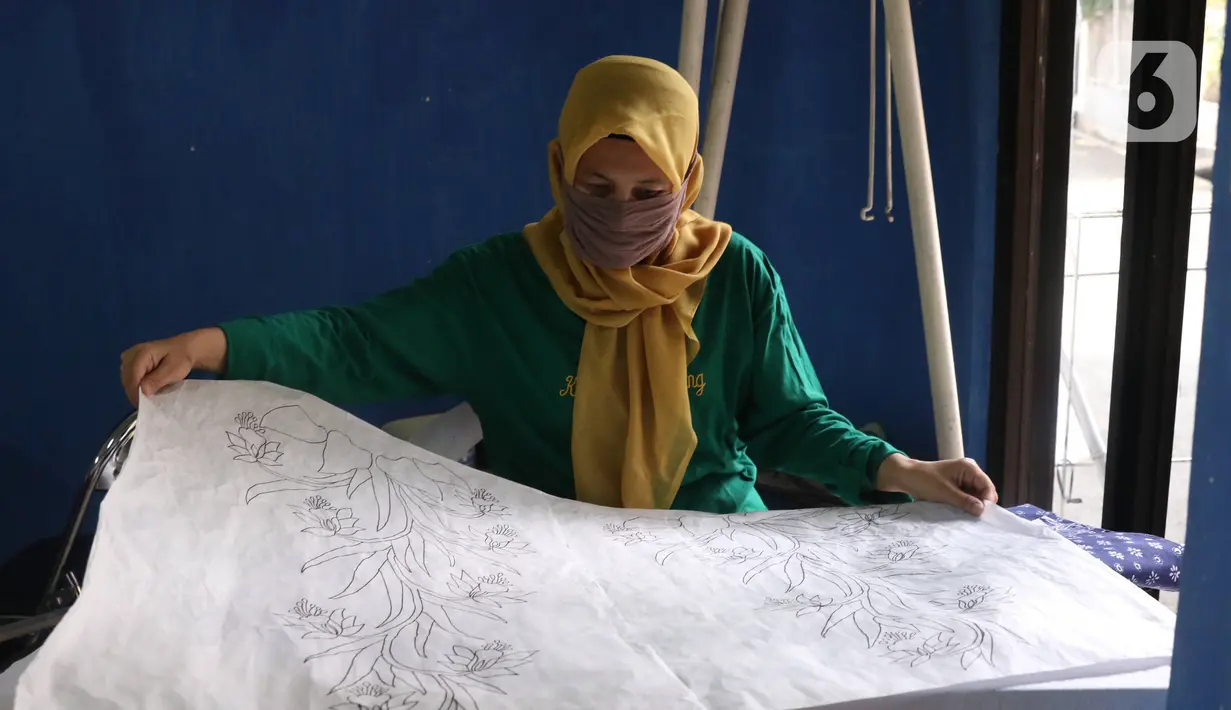 Perajin mengecek motif batik tulis di Sanggar Batik Kembang Mayang, Larangan, Tangerang, Banten, Minggu (19/7/2020). Proses pembuatan batik di sanggar tersebut mulai berjalan kembali setelah terhenti saat diberlakukan PSBB. (Liputan6.com/Angga Yuniar)