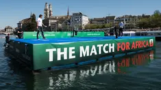 Petenis asal Swiss, Roger Federer (kiri) bertanding melawan petenis asal Inggris, Andy Murray di lapangan kecil di atas sungai Kota Zurich, Senin (10/4). Kedua petenis itu terlibat dalam program amal The Match For Africa 3. (Ennio Leanza/Keystone via AP)