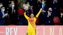Striker Barcelona, Lionel Messi, mengangkat trofi usai menjuarai Copa del Rey di Stadion Olimpico de Sevilla, Minggu (18/4/2021). Barcelona menang 4-0 atas Athletic Bilbao. (AFP/Cristina Quicler)