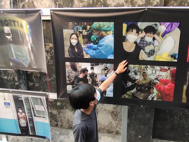 Warga melihat pameran foto jurnalistik karya pewarta foto Indonesia Tangerang di kawasan Pasar Lama, Tangerang, Minggu (30/5/2021). Pameran foto bertajuk meredanya Covid-19 ini bertujuan agar masyarakat dapat mengenal bahaya Covid-19 yang tengah mewabah di Indonesia.  (Liputan6.com/Angga Yuniar)