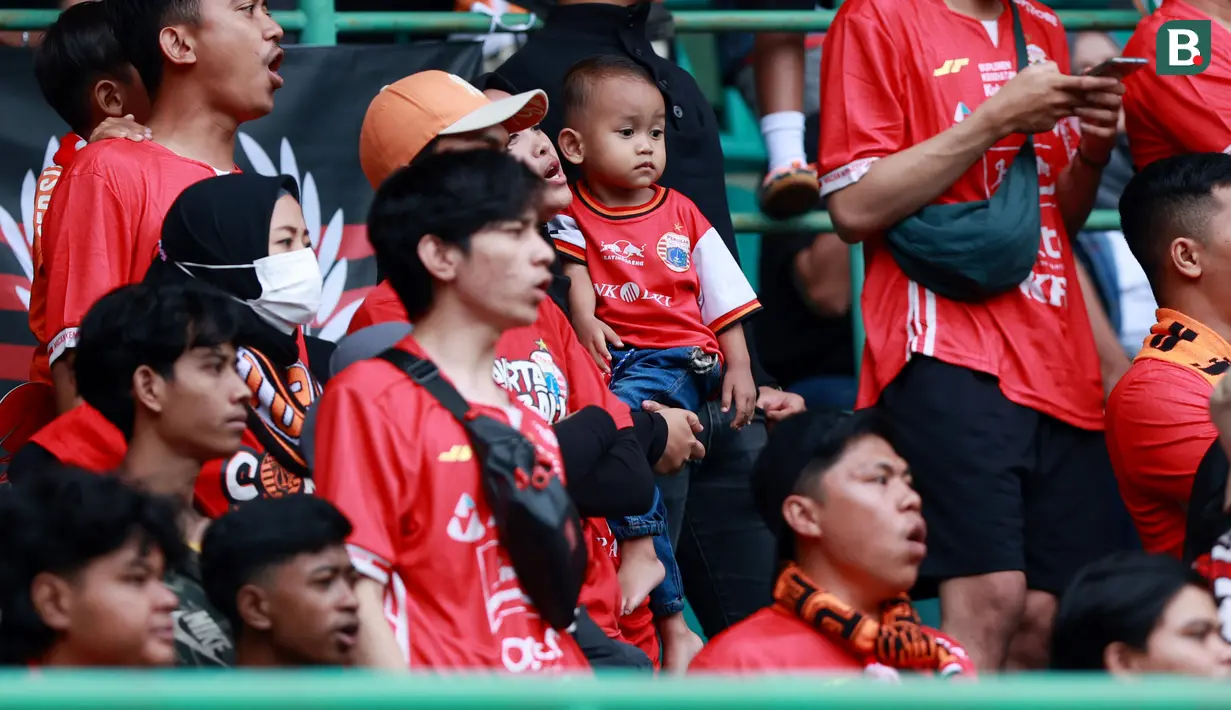 Suporter Cilik saat menyaksikan pertandingan Persija Jakarta melawan Arema FC pada laga BRI Liga 1 di Stadion Patriot Candrabhaga, Bekasi, Minggu (12/2/2023). Orang tua yang juga fans Persija sudah mulai menularkan kecintaan mereka pada Macan Kemayoran sejak dini. (Bola.com/M Iqbal Ichsan)