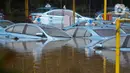 Sejumlah taksi terendam banjir di Pool Taksi Bluebird kawasan Kramat Jati, Jakarta, Selasa (25/2/2020). Meluapnya Kali Cipinang membuat Pool Taksi Blue Bird yang berada tepat di samping kali ikut terdampak banjir. (Liputan6.com/Herman Zakharia)