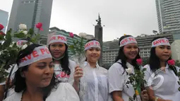 Dalam aksi damai "Save Polri" peserta aksi membagikan bunga mawar kepada warga, Bundaran HI, Jakarta, Minggu (1/2/2015). (Liputan6.com/Herman Zakharia)