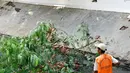 Petugas Dinas Kebersihan DKI Jakarta mengangkat sampah pohon di saluran air Bundaran HI, Jakarta, Minggu (15/11/2015). Memasuki musim hujan, Pemda DKI Jakarta giat membersihkan saluran air. (Liputan6.com/Yoppy Renato)