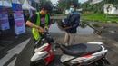 Warga saat mengantarkan motornya yang akan diberangkatkan menuju kampung halaman saat  kegiatan program mudik motor gratis Lebaran 2024 di Terminal Pondok Cabe, Tangerang Selatan, Banten, Jumat (5/4/2024). (merdeka.com/Arie Basuki)