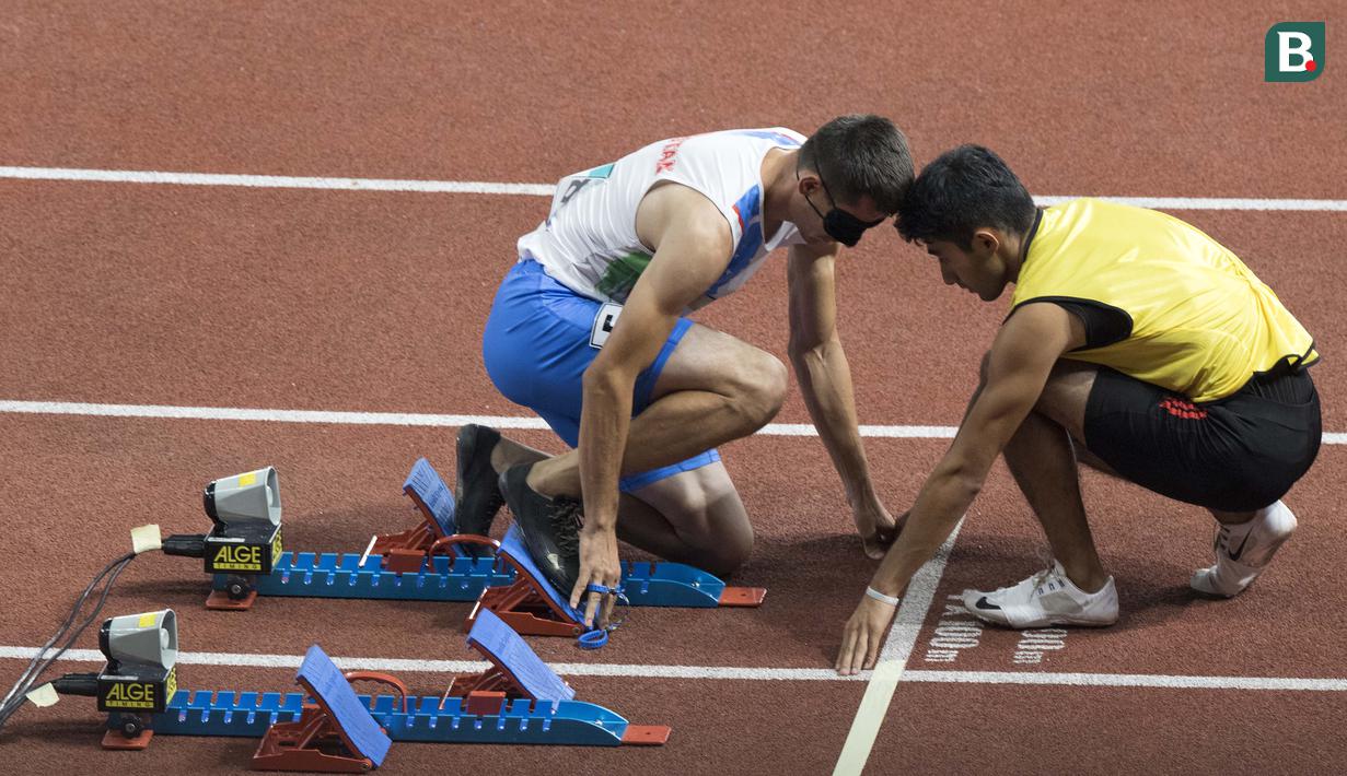 Aksi Sakhatov Miran atlet cabang para atletik asal Uzbekistan didampingi pemandunya di nomor lari 400 meter putra klasifikasi T11 pada Asian Para Games 2018, di Stadion Utama Gelora Bung Karno Jakarta, Kamis(11/10/2018).  (Bola.com/Peksi Cahyo)