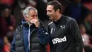 Pelatih Derby County, Frank Lampard, berbincang dengan pelatih Manchester United, Jose Mourinho, pada Piala Liga Inggris di Stadion Old Trafford, Rabu (26/9/2018). Manchester United takluk adu penalti 9-10 (2-2) dari Derby County. (AFP/Paul Ellis)