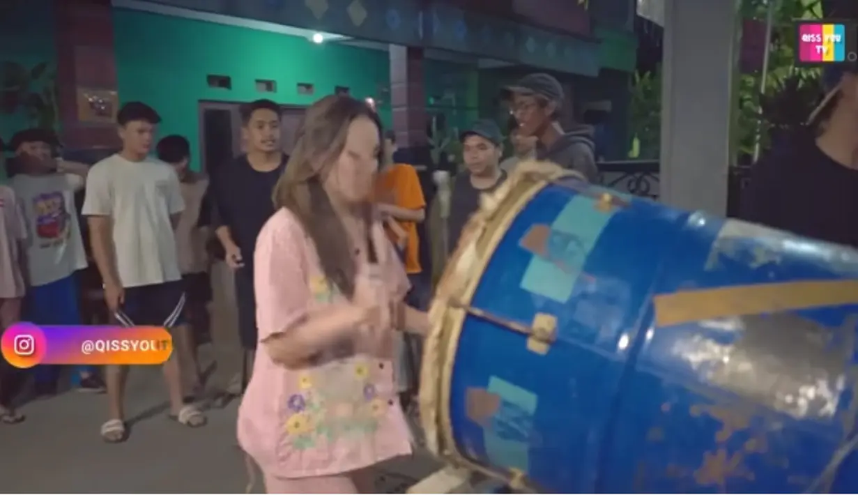 Penyanyi dangdut papan atas yang juga komedian itu tampak santai menabuh bedug. Tidak berdandan, Ayu tampil apa adanya. [Youtube/Qiss You TV]
