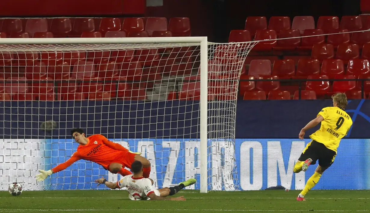 Pemain Borussia Dortmund Erling Haaland (kanan) mencetak gol ke gawang Sevilla pada leg pertama babak 16 besar Liga Champions di Stadion Ramon Sanchez Pizjuan, Seville, Spanyol, Rabu (17/2/2021). Borussia Dortmund menang 3-2. (AP Photo/Angel Fernandez)